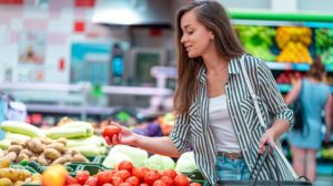 woman-shopping-basket-chooses-purchases-fresh | Why You Should Shop At Your Local Health Food Stores | featured