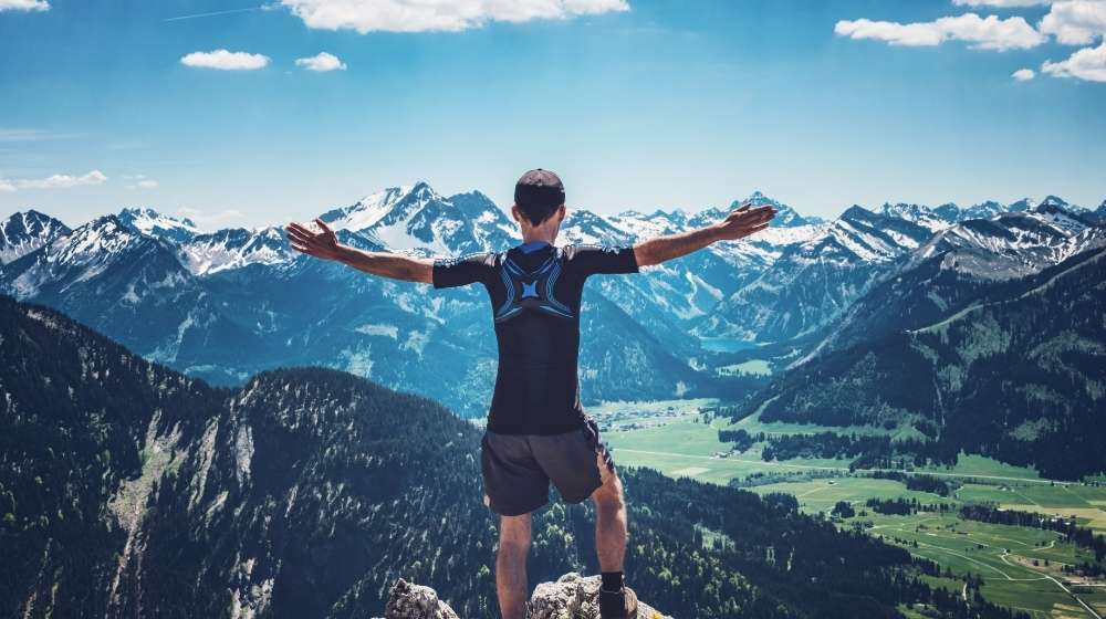 hiker-reaching-the-summit | An Easy & Effective Guide To Breaking Bad Habits | featured