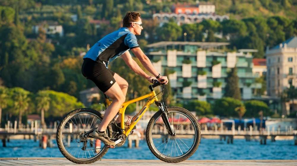 man-cycling-by-the-sea | How Bicycling Can Relieve Arthritis Pain | featured