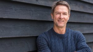 Portrait shot of an attractive, successful and happy middle aged man male arms folded outside wearing a blue sweater | How To Be Optimistic & Live A Better Life | featured