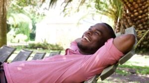 relaxed-young-man-lying-outdoors-on-a-hammock-relaxation-techniques | Relaxation Techniques To Reduce Stress | featured