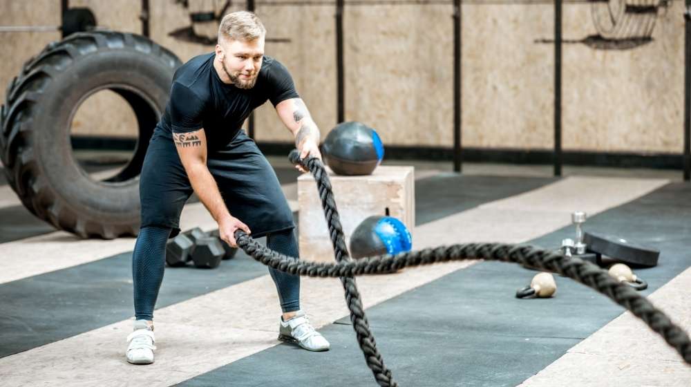 man-training-with-a-rope-in-the-gym-how-to-build-endurance | How To Build Your Endurance And Stamina | Featured