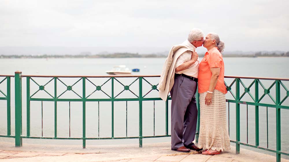 stylish elderly couple kissing on embankment | Dating in Your 50s Dos and Don'ts | Featured