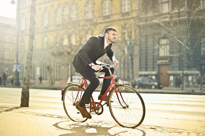 man in black suit riding bicycle down the street | fat tire bike for everyday use