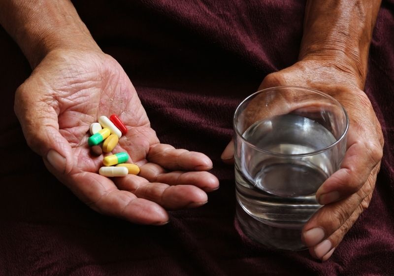 A lot of colored pills and a glass of water | 10 Tips for Preventing Alzheimer's Disease