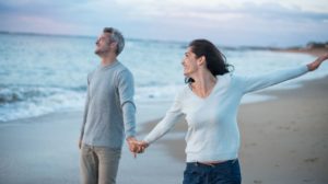 Beautiful couple walking on the beach | 19 Rules to Throw Out When You Turn 50 | Featured