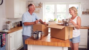 Senior Couple Downsizing In Retirement Packing And Labelling Boxes Ready For Move Into New Home | All About Home Downsizing | featured