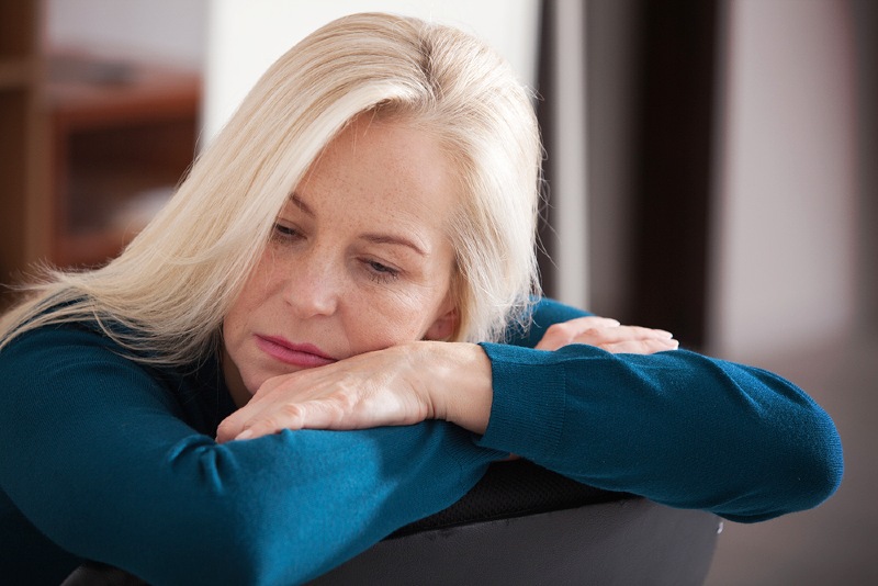 sad depressed woman home sitting on | emotional detox symptoms