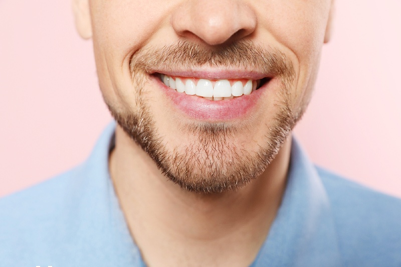 smiling man perfect teeth on color | Sensitive teeth symptoms