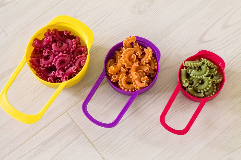 Colorful raw pasta in color measure cups-Weight Loss