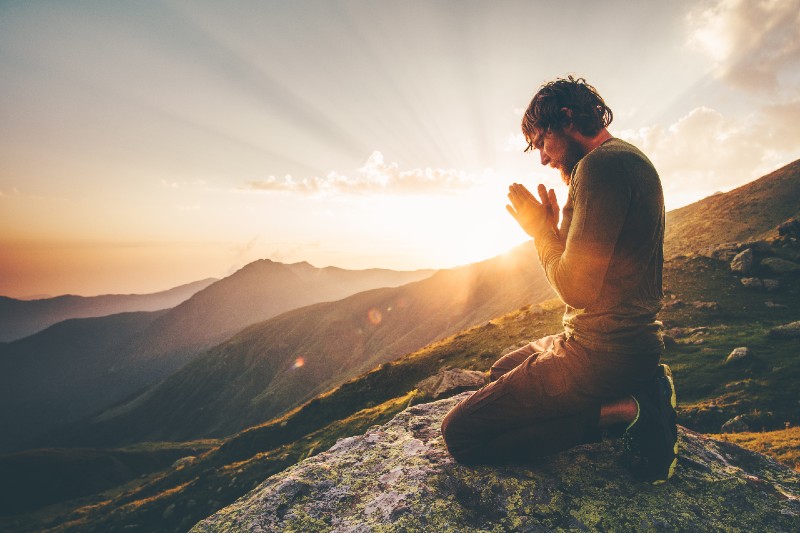 Man praying alone at sunset mountains Travel Lifestyle spiritual relaxation-Good Nutrition and Physical Fitness