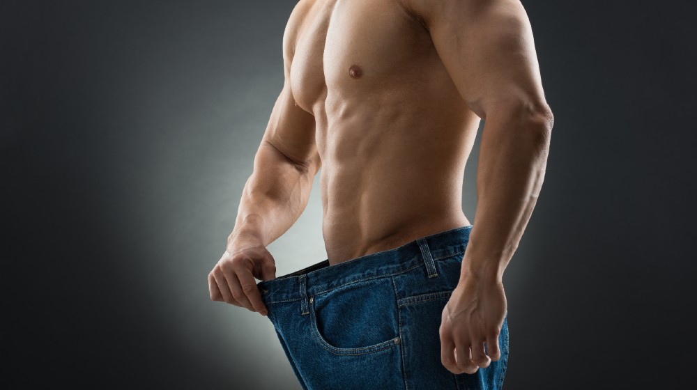 Midsection of muscular man in old jeans showing weight loss | Weight Loss - 5 Tips For Success (For Men Only) | featured