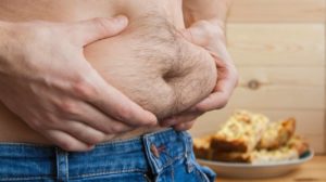 Overweight man, hand holds excessive fat on his stomach | How to Reduce Tummy Fat For Men | featured