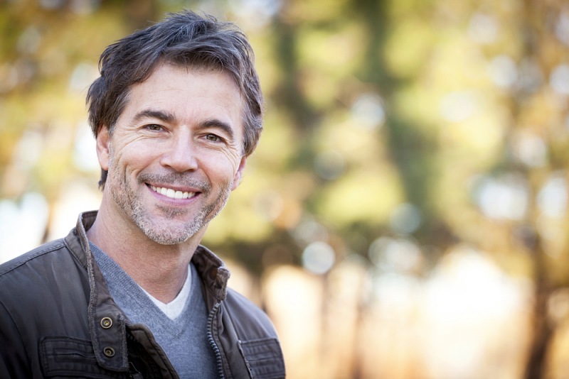 handsome mature happy man smiling camera | best vitamins for men over 50