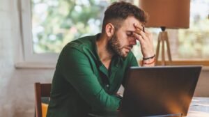 Man Having Stressful Time Working | Stress Symptoms | Featured