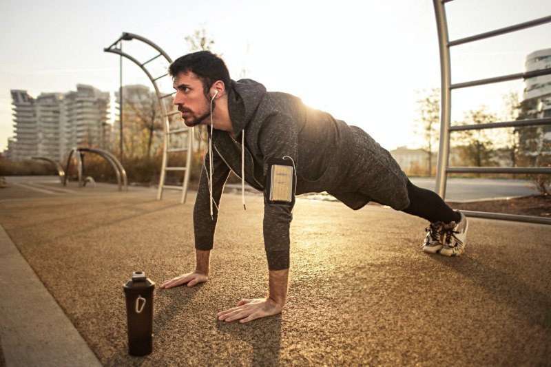 man in gray jacket doing push ups during sunrise | best exercise program for men over 50