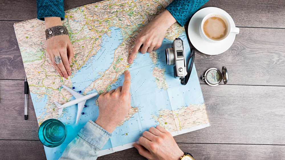 young couple planning honeymoon vacation trip | Great Travel Destinations For After You Retire | Featured