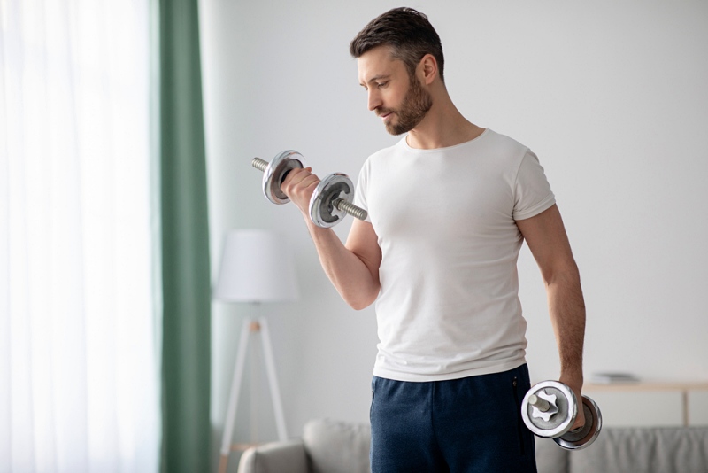 closeup handsome middleaged man doing dumbbell | ways to improve mental health