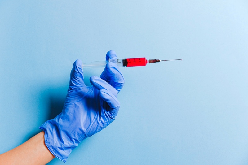 person holding syringe | vaccine covid