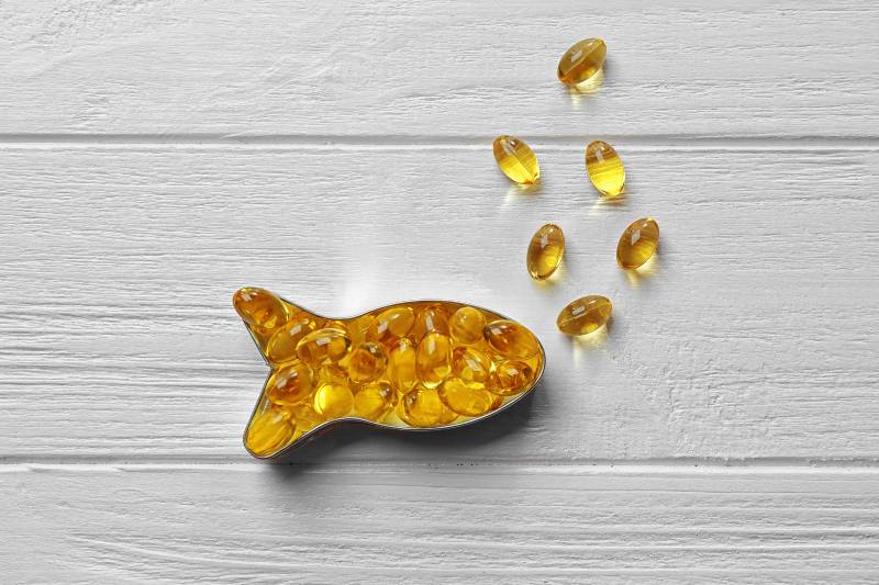 Capsules of cod liver oil arranged in a fish shape on white wooden background-Improve Your Memory