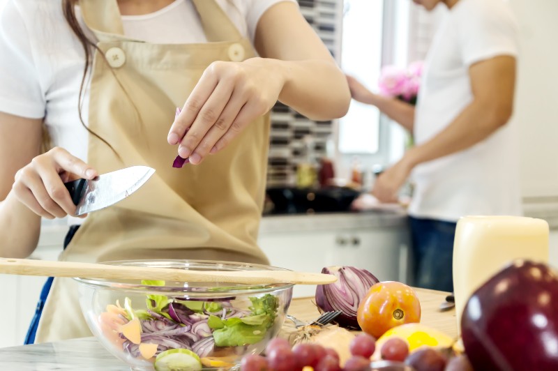 Closeup Young woman cutting slice vegetables making salad heathy food-Coronavirus Safety Tips
