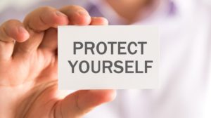 Closeup on businessman holding a card with PROTECT YOURSELF message | 5 Coronavirus Safety Tips to Protect Yourself | featured