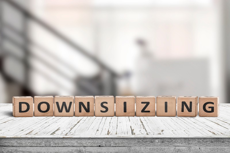 Downsizing message sign made of wood on a white desk in an office environment-Baby Boomers