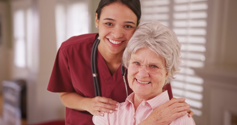 Latina caretaker with senior woman smiling-Dementia