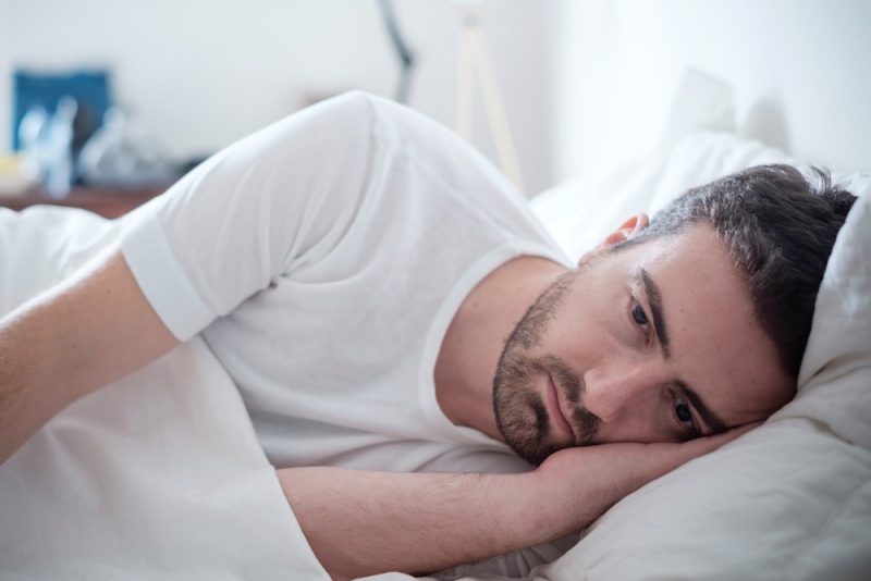 depressed man lying his bed feeling | kidney problems symptoms