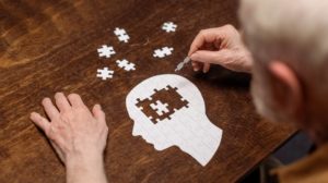 high angle view of senior man collecting jigsaw puzzle as dementia rehab | Bathing With Dementia | featured