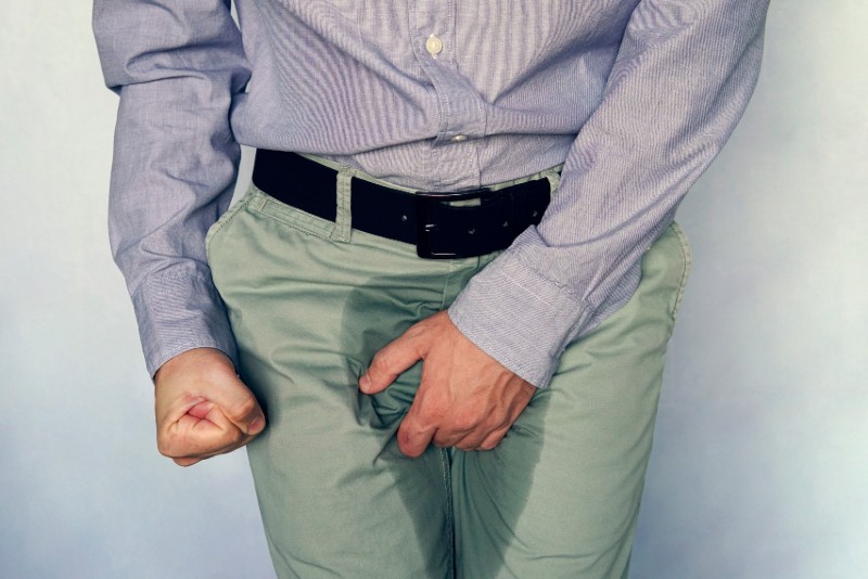 men are scratching the penis against blue gray background-Urinary Incontinence