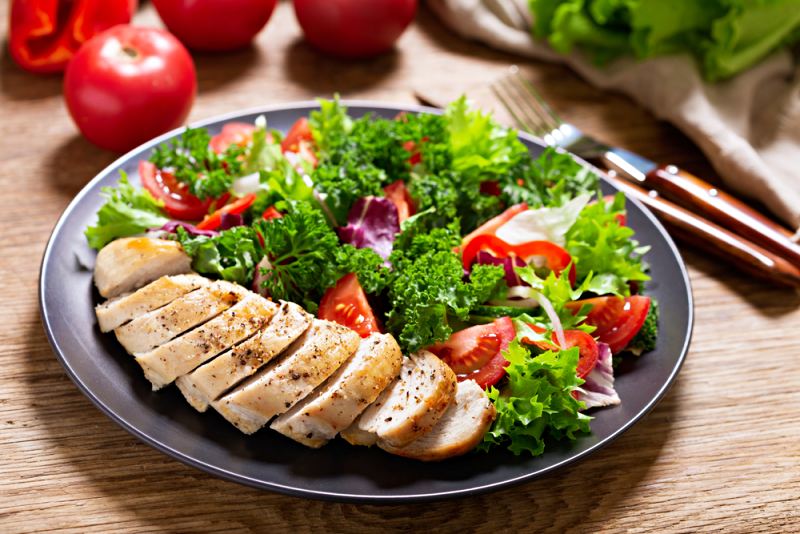 plate chicken salad vegetables on wooden | Menopause weight gain supplements