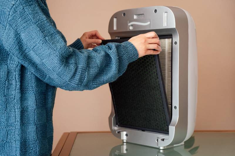 Hands changing air, dust, carbon and hepa purifier filters-Delta Variant