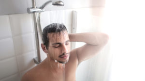 Man warming up in the shower _ Hot Bath Benefits