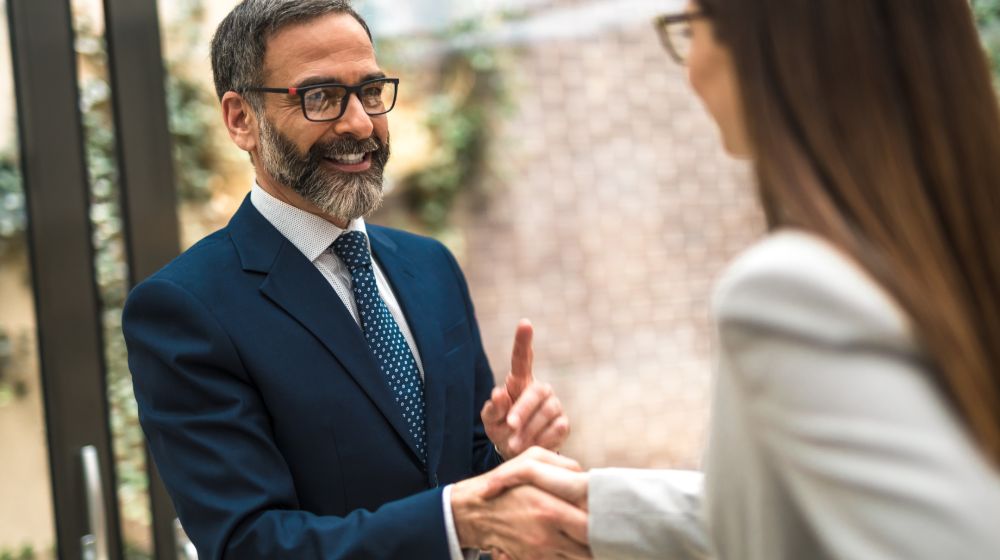 Senior professionals shaking hands | How to avoid age discrimination when looking for a job | Featured