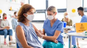 Woman with face mask getting vaccinated, coronavirus, covid-19 and vaccination concept | 6 Reasons We Are Still Not Rid Of This Virus Despite Vaccinations! | featured