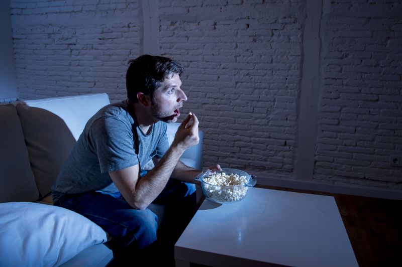 Young television addict man sitting | Revenge sleep procrastination