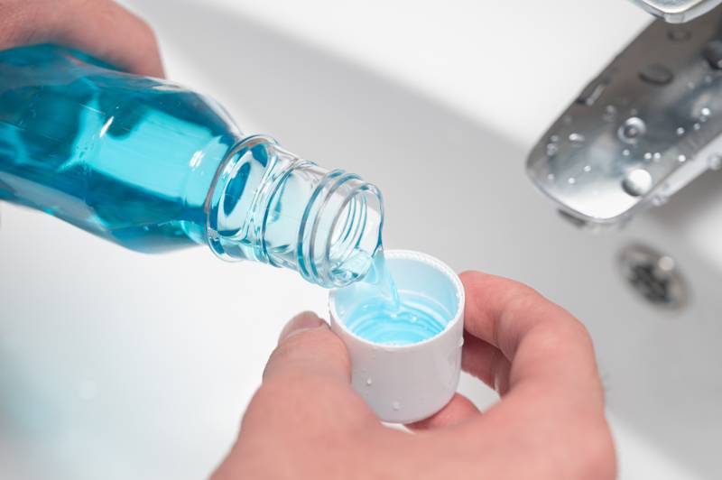 hand-man-pouring-bottle-mouthwash-into truth about mouthwash SS