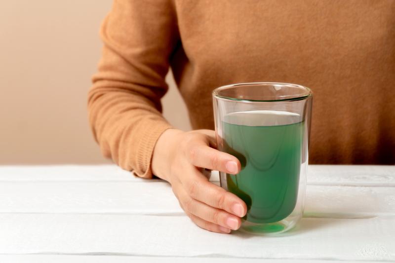 woman-hand-holding-cup-chlorophyll-water | benefits of liquid chlorophyll