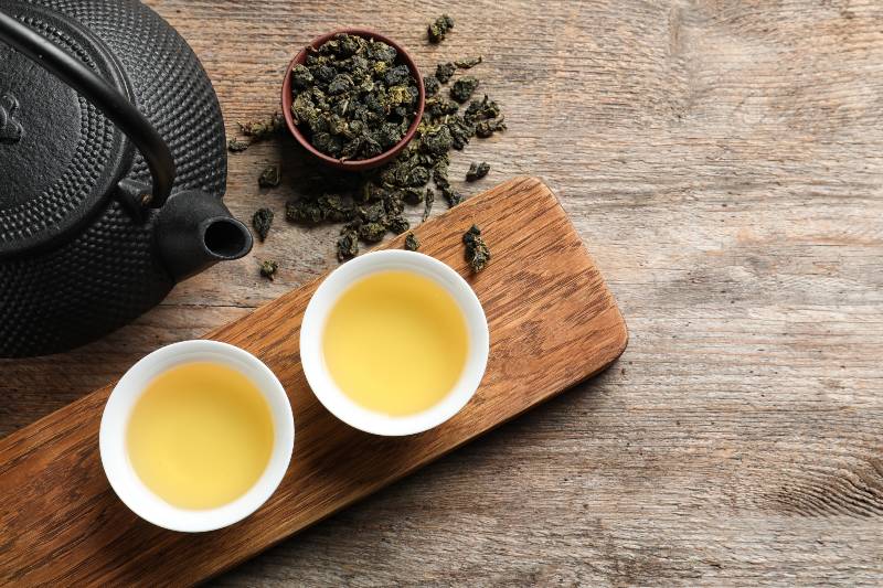 Cups and teapot of Tie Guan Yin oolong on wooden background-oolong tea