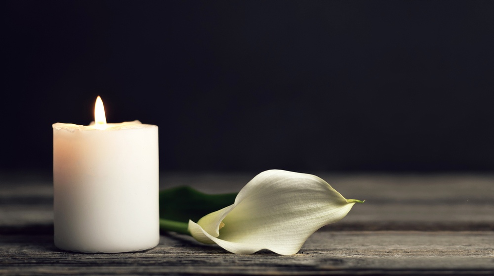 burning candle white calla lily on | How to Cope with Loss of Husband | Featured