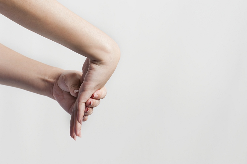 closeup woman stretching his hand wrist | top of wrist pain