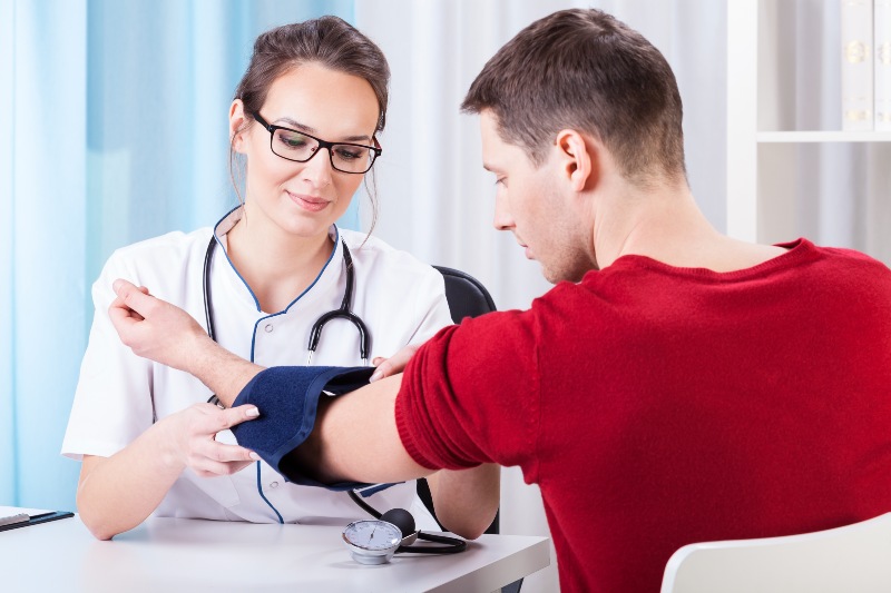 Doctor Measuring Blood Pressure of Young Man | What Does DASH Diet Mean