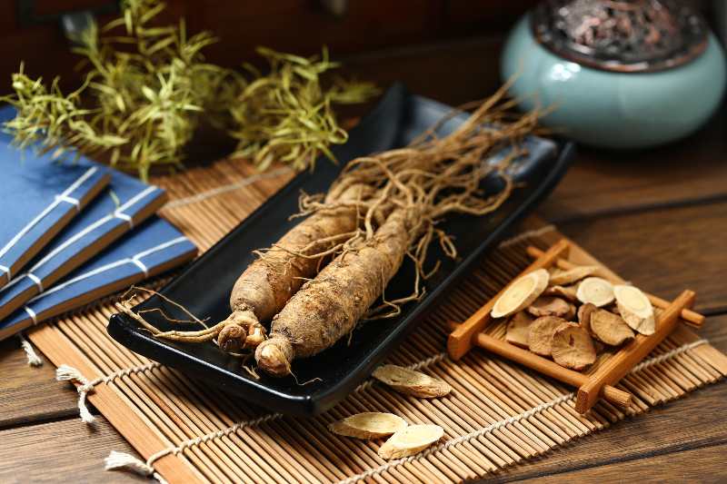 ginseng in black plate on wooden table-Diabetes Herbal Treatments
