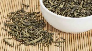 loose leaf Sencha green tea in a white china cup | Sencha Green Tea and Its Benefits | featured