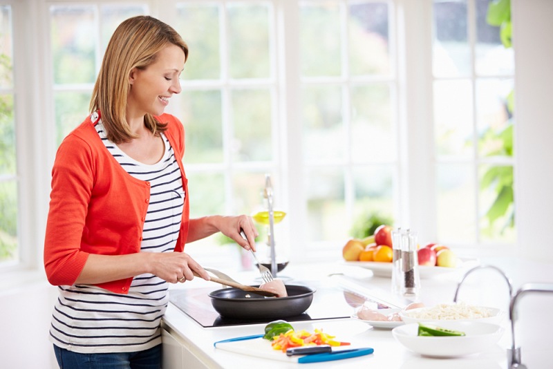 woman standing hob preparing meal kitchen | what is fodmap diet