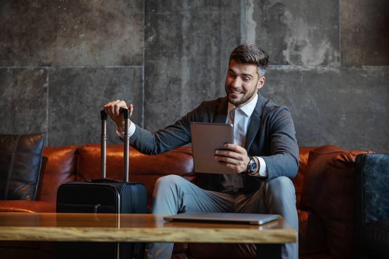 A happy businessman is sitting on a couch in the hotel lobby-Transform Yourself