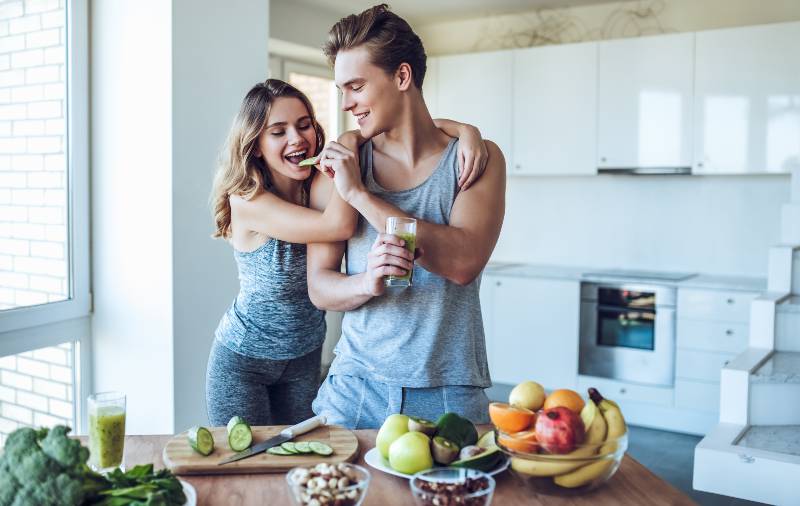 Happy sporty couple is preparing healthy food on light kitchen-daniel fast