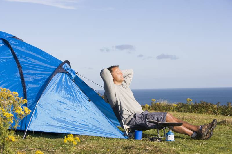 Man camping outdoors and cooking-Why Camping Is Good For Your Health