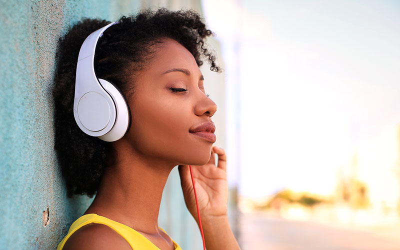Pretty girl listening music with her headphones in the street | Does Tinnitus Go Away | 9 Signs That Tinnitus is Going Away